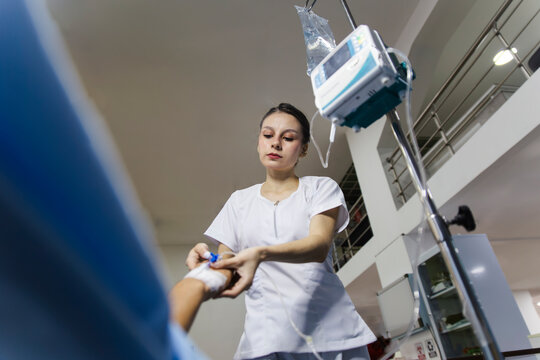 Nurse performing an intravenous procedure in a hospital setting