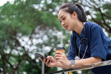 Doctor using smartphone while enjoying coffee outdoors