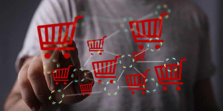 Hand interacts with a digital network of shopping carts, symbolizing online shopping and e-commerce. - Powered by Adobe