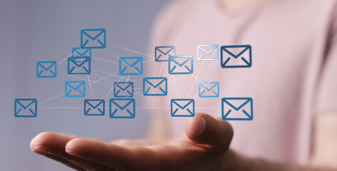 Hand holding digital email icons, network connection, communication, global reach.