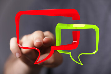 Person using finger to interact with digital speech bubbles.  Communication, conversation, feedback...