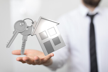Image of house keys held by a real estate agent, symbolizing homeownership and new beginnings.