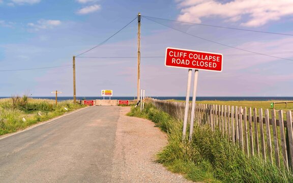 Warning road signs of Coastal erosion along coastline in Aldbrough, Yorkshire, UK.
