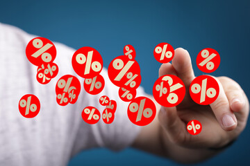 Image of a hand interacting with floating percentage symbols, ideal for finance, sales, discount...