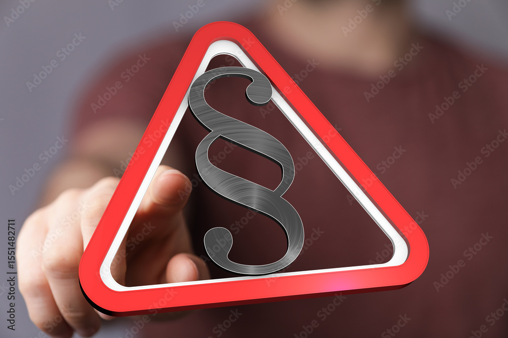 Poster hand pointing at a digital red triangle warning sign with a paragraph symbol. legal concept.