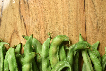 Group Of Fresh Hyacinth Bean or Same Ki Phalli On Wooden Table Close Up With Background Blur