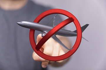 Image of a hand rejecting a plane with a no symbol. Perfect for travel restrictions, cancellations,...