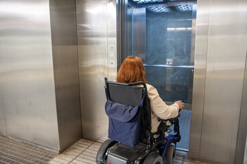 Woman in wheelchair entering elevator in subway station,. Concept of inclusion, adapted public