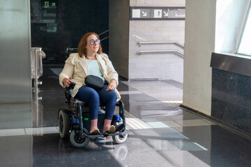 Businesswoman in wheelchair navigating modern subway station. Concept of inclusion, adapted public