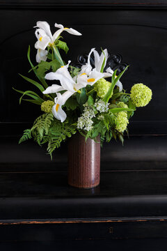 Vintage bouquet of late spring flowers with Dutch iris and guelder-rose in a studio setting