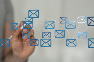 Hand interacting with a network of email icons.  Digital communication.