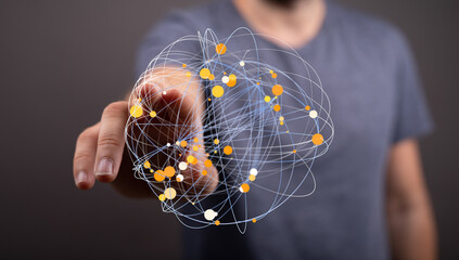 A person's finger interacts with a 3D network graphic, representing global connections or data.