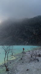 Photographer taking pictures at Kawah Putih, a misty volcanic crater lake in Ciwidey, West Java, Indonesia. 