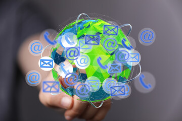 Image depicts a hand interacting with a digital globe showing email, phone, and internet connection...