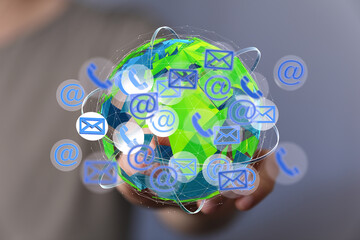 A hand holds a digital globe with email, phone, and internet icons, symbolizing global...