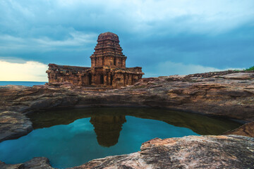 Ancient upper shivalaya temple  reflecting in a rock pond beneath a cloudy evening sky at Badami, Karnataka, India.