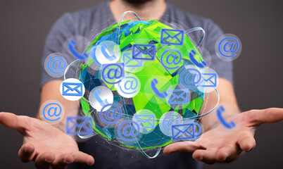 Person holding a digital globe with email, phone, and internet symbols. Global communication...