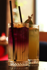 Delicious lemonades in glass cups. Refreshing drinks in a cafe or restaurant. Lavender lemonade close-up. Glass cup with a tasty bright drink and a straw. Cocktails