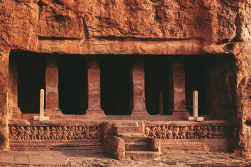 Historic rock-cut cave temple with carved stone pillars in Badami, India.	