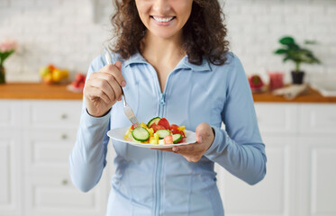 Cropped shot of happy smiling young woman in sportswear with beautiful slim sportive body standing...