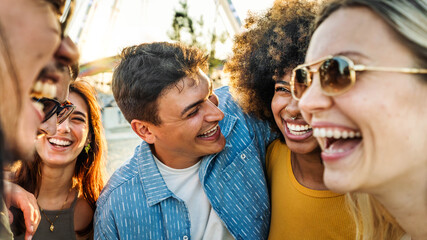 Multiethnic young people laughing together outside - Friendship life style concept with guys and girls having fun together hanging outdoors - Boys and girls talking and smiling on city street