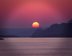 Vibrant sunset over mountain landscape and sea, dramatic pink and purple sky, scenic seascape with layered hills