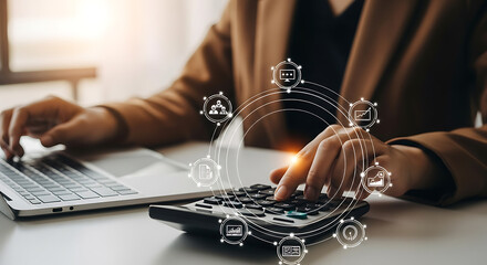 Business professional calculating financial data using calculator and laptop with digital icons.