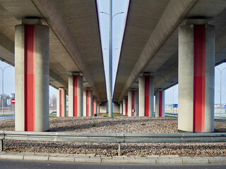 Underneath a Modern Concrete Overpass with Red Pillars
