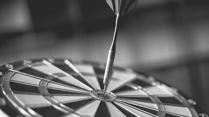 Dart arrow hitting in the target center of dartboard
