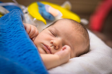 sleeping newborn baby with toon bear and moon under blue blanket
