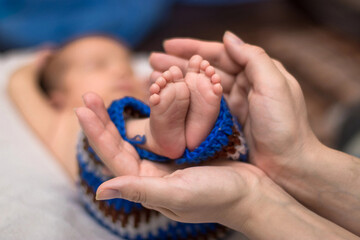 Parent holding in the hands feet of newborn baby