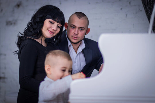 the child plays the piano for mom and dad - Powered by Adobe