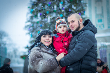 Obraz premium happy family, mom, dad and son near the Christmas tree