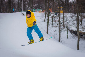 snowboarder rides on mountain slope on snow winter
