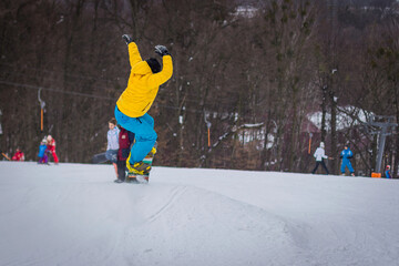 snowboarder rides on mountain slope on snow winter