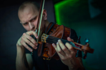 The violinist plays the violin. Brutal man with a beard playing the violin fatal simony. Close-up