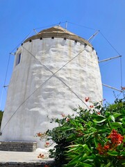 Closeup view of a traditional Cycladic windmill in Parikia on Paros island, Greece - one of many iconic, whitewashed windmills that are a charming symbol of the island’s rich cultural heritage.