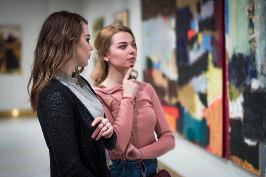 two girls discuss paintings in Gallery of contemporary art