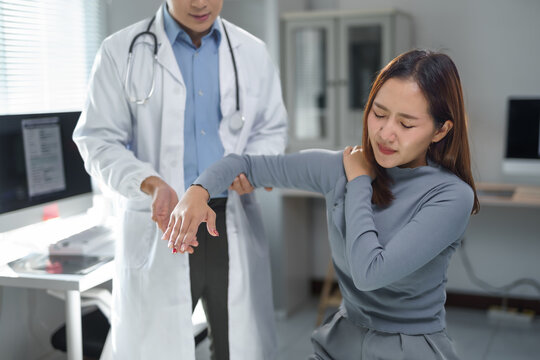 Doctor checking arm and shoulder joint of patient suffering from chronic joint pain in hospital