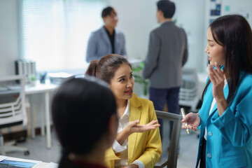 Asian businesswomen engaging in discussion and brainstorming during a meeting in a modern office...