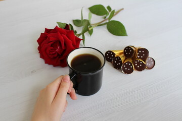 a cup of coffee with interesting chocolates and a cute red rose is a nice start to the day