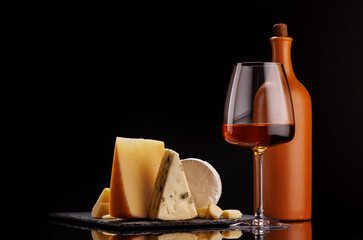 A refined selection of aged cheeses presented on a board, accompanied by a glasses of wine