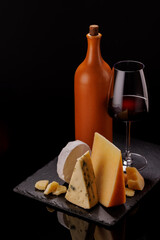 A refined selection of aged cheeses presented on a board, accompanied by a glasses of wine