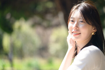 白トップスの女性がカメラに向かって爽やかに微笑む春のポートレート