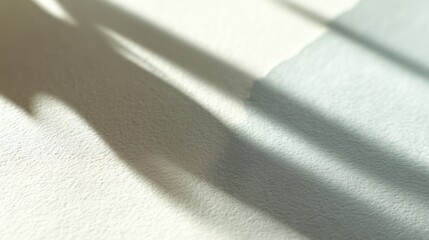 Soft natural light casting long shadows on textured light beige wall surface during early morning or late afternoon sunlight soft focus calm atmosphere