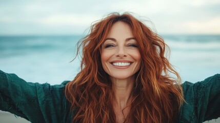 A vibrant woman spreads her arms wide against the backdrop of a beautiful beach, radiating joy and positivity while enjoying the refreshing sea breeze and sunshine.