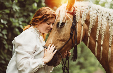 A woman is wearing a cowboy hat while riding a horse in an open field