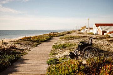 Empty wheelchair in the sun, near the ocean