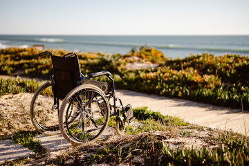 Empty wheelchair in the sun, near the ocean