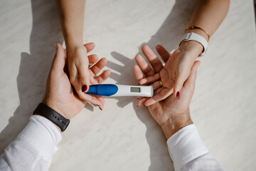 Man and woman holding pregnancy test